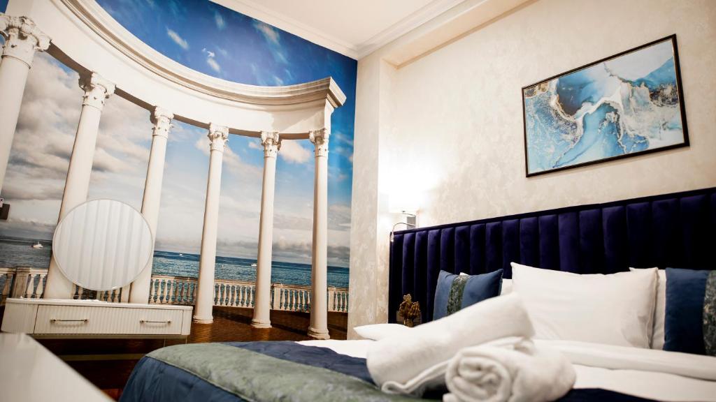 a bedroom with a wall mural of a wave at Essam Deluxe Hotel in Baku