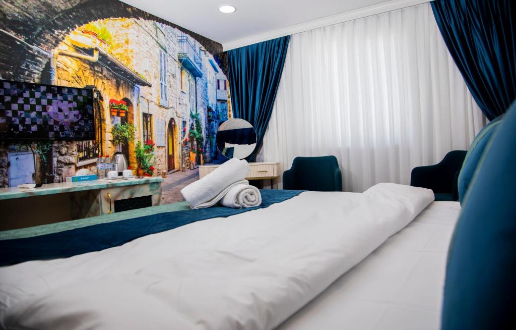 una camera d'albergo con un letto e un dipinto sul muro di Essam Deluxe Hotel a Baku