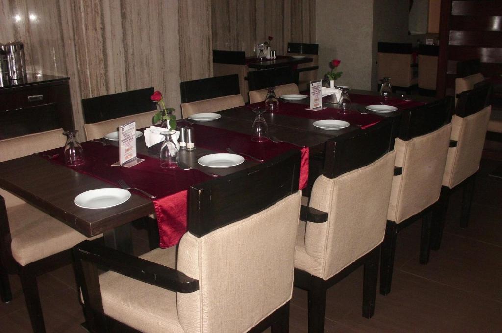 a long dining room table with chairs and red table runners at SVN GRAND in Kākināda