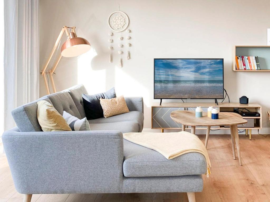 a living room with a couch and a tv at Beach Loft in Zingst