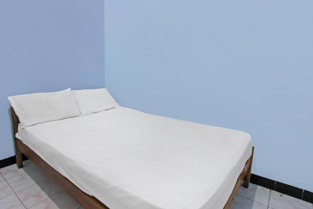 una cama con sábanas blancas en una habitación en SPOT ON 92567 Jati Homestay, en Lombok