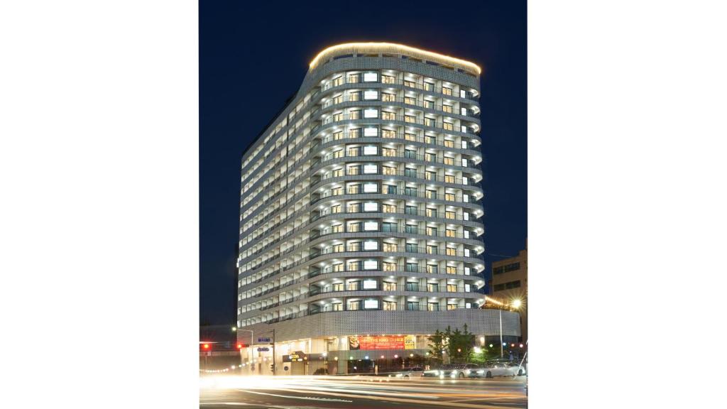 a tall building is lit up at night at Chuncheon Eston Hotel in Chuncheon