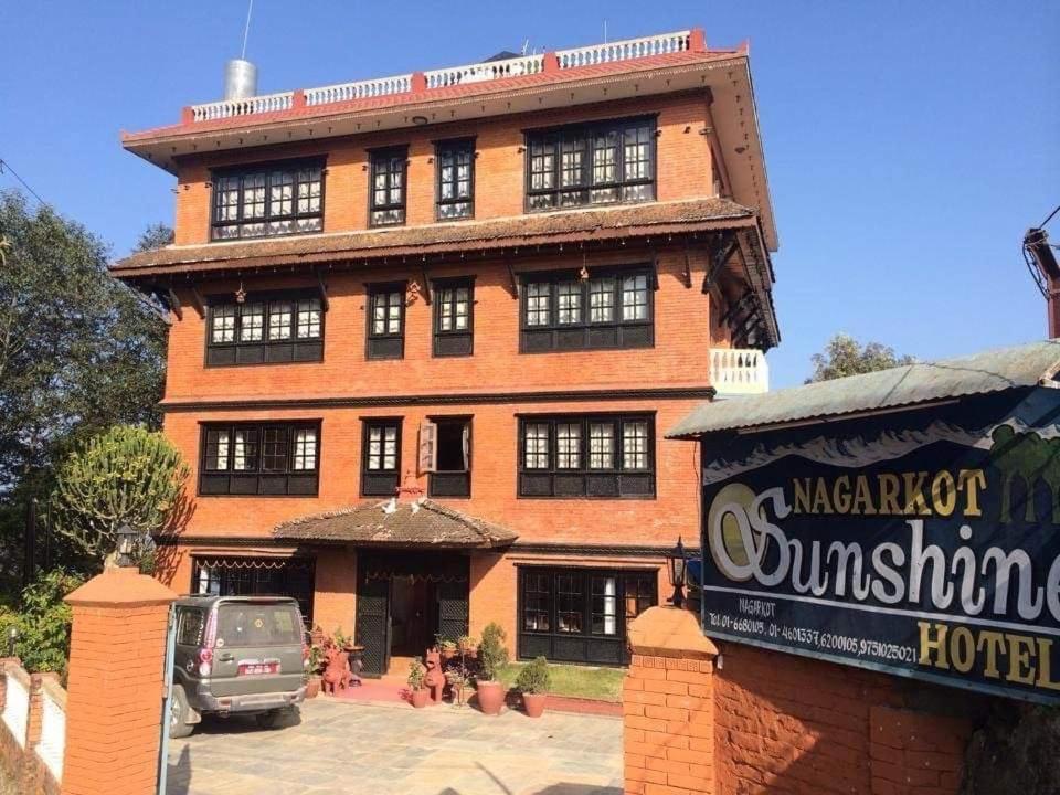 a large brick building with a sign in front of it at Nagarkot Sunshine Hotel in Nagarkot