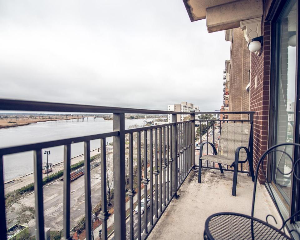 a balcony with chairs and a view of the water at Water Street Retreat 14 in Wilmington