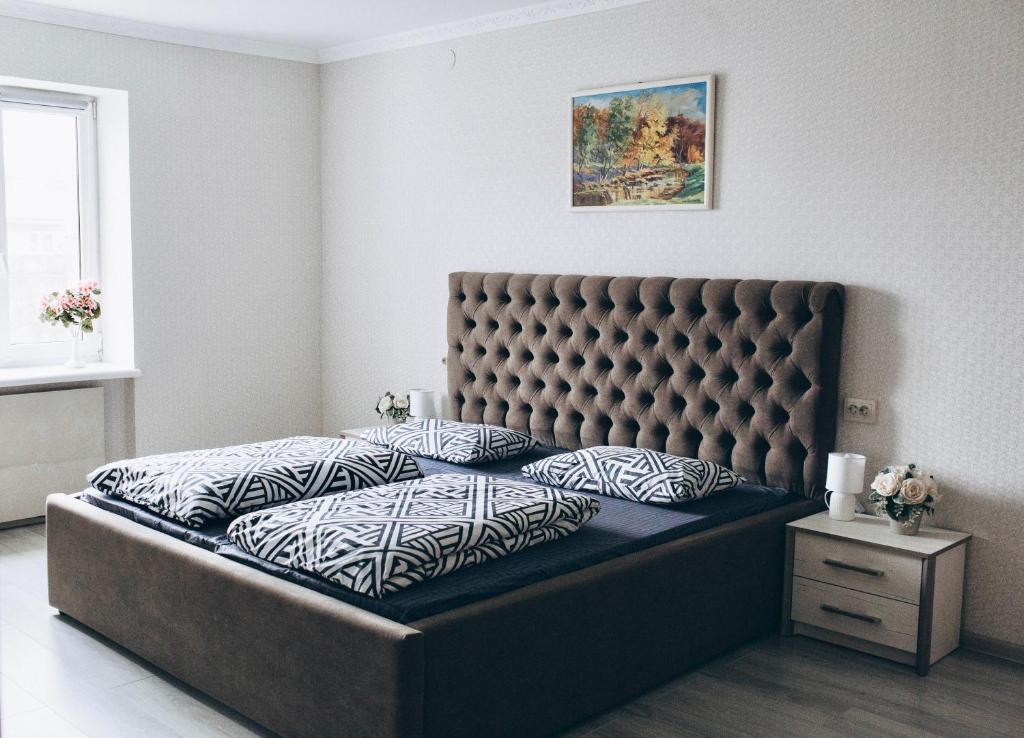 Schlafzimmer mit einem großen Bett mit einem gepolsterten Kopfteil in der Unterkunft Однокімнатна дизайнерська квартира поруч з термальними водами in Berehowe