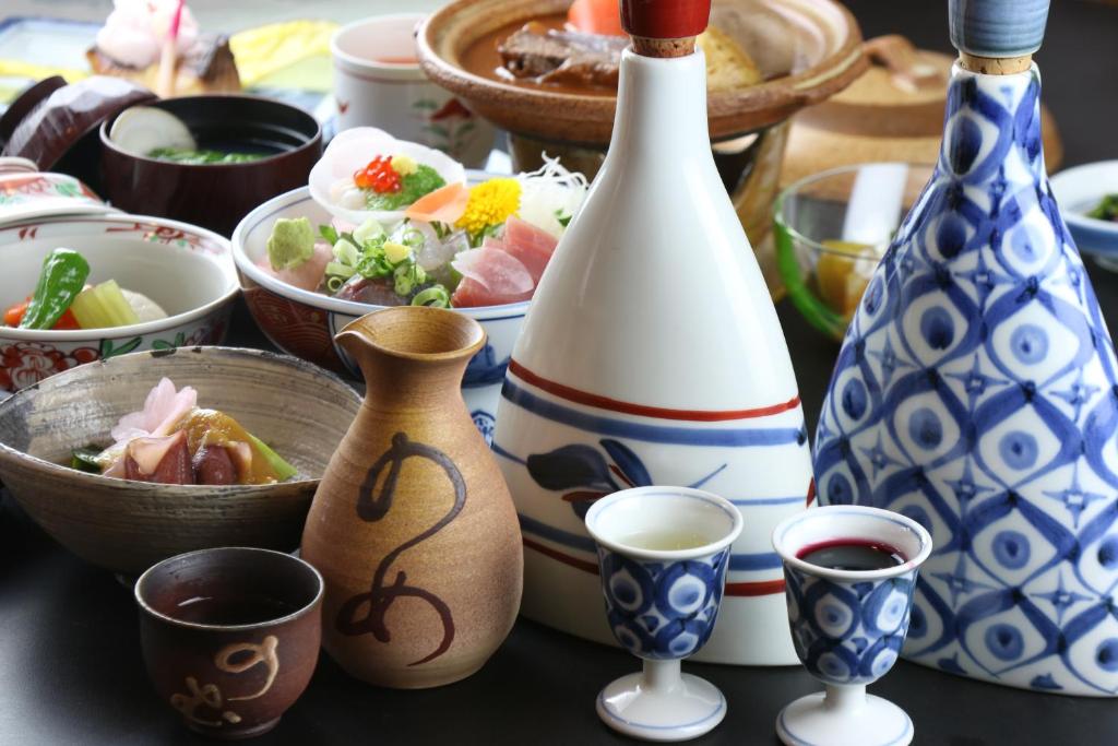 a table with bowls of food and a bottle of wine at Teiensaryo Yamanakako in Yamanakako