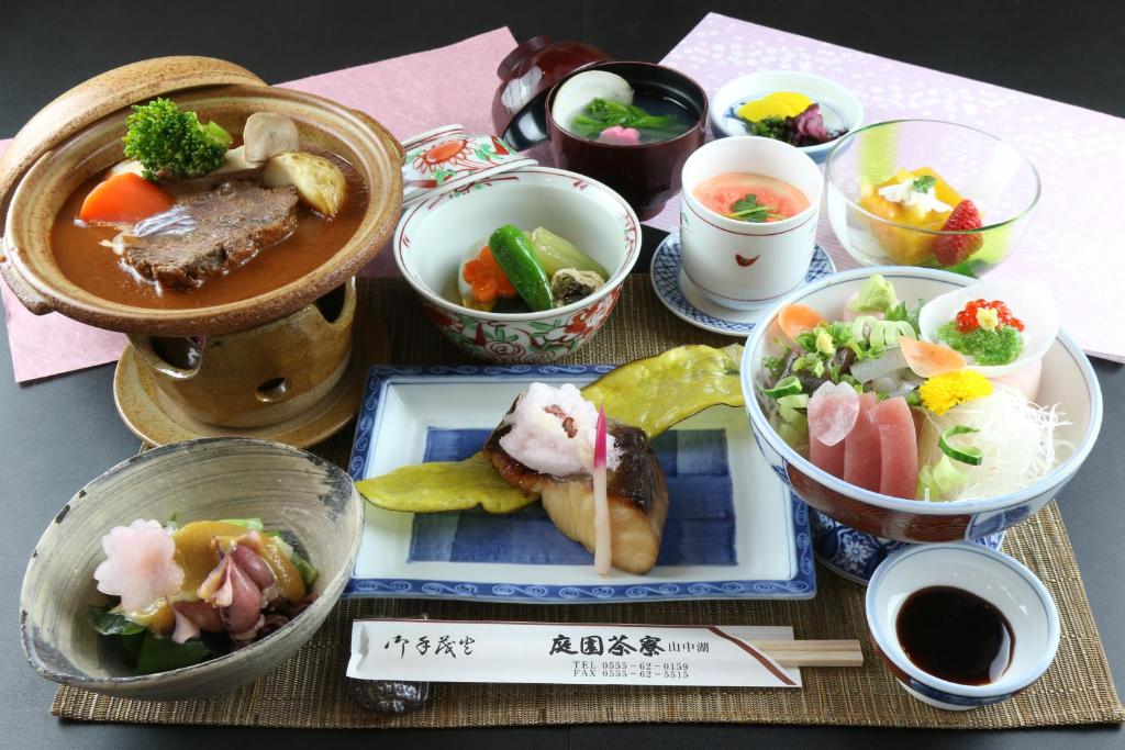 a table topped with plates of food and bowls of food at Teiensaryo Yamanakako in Yamanakako