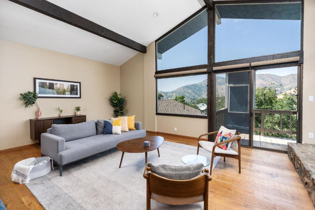 sala de estar con sofá, sillas y ventanas en Mountain View, Hot Tub, Open Kitchen, 10m to Sequoia en Three Rivers