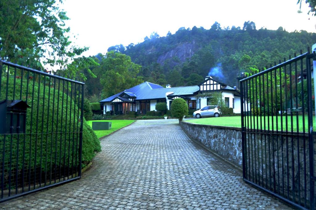un cancello di fronte a una casa con vialetto di Hill Cottage a Nuwara Eliya