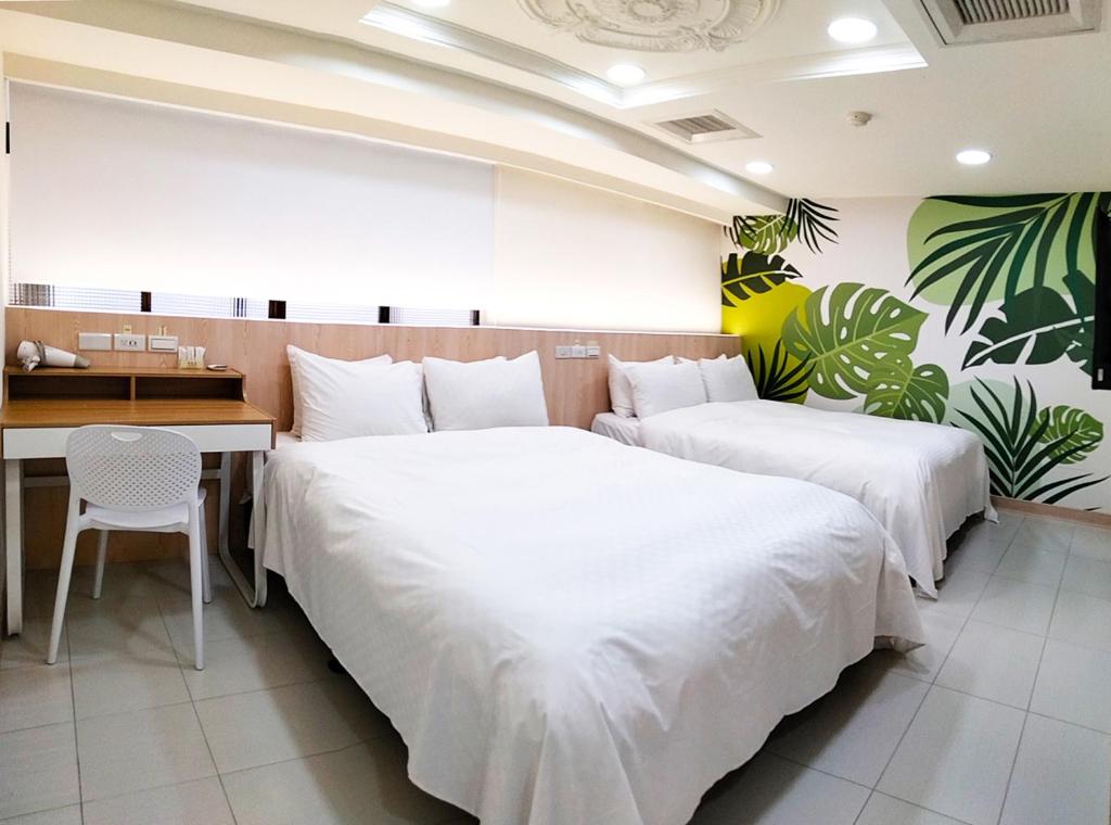 - 2 lits dans une chambre d'hôtel avec un bureau et une table dans l'établissement Beethoven Express Hotel, à Zhongli