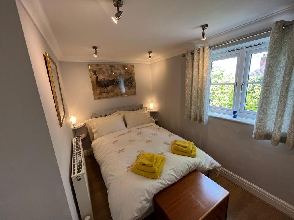 een slaapkamer met een bed met twee gele handdoeken erop bij 3-bed cottage in Sway, New Forest (5 min walk from Sway Train Station) in Sway