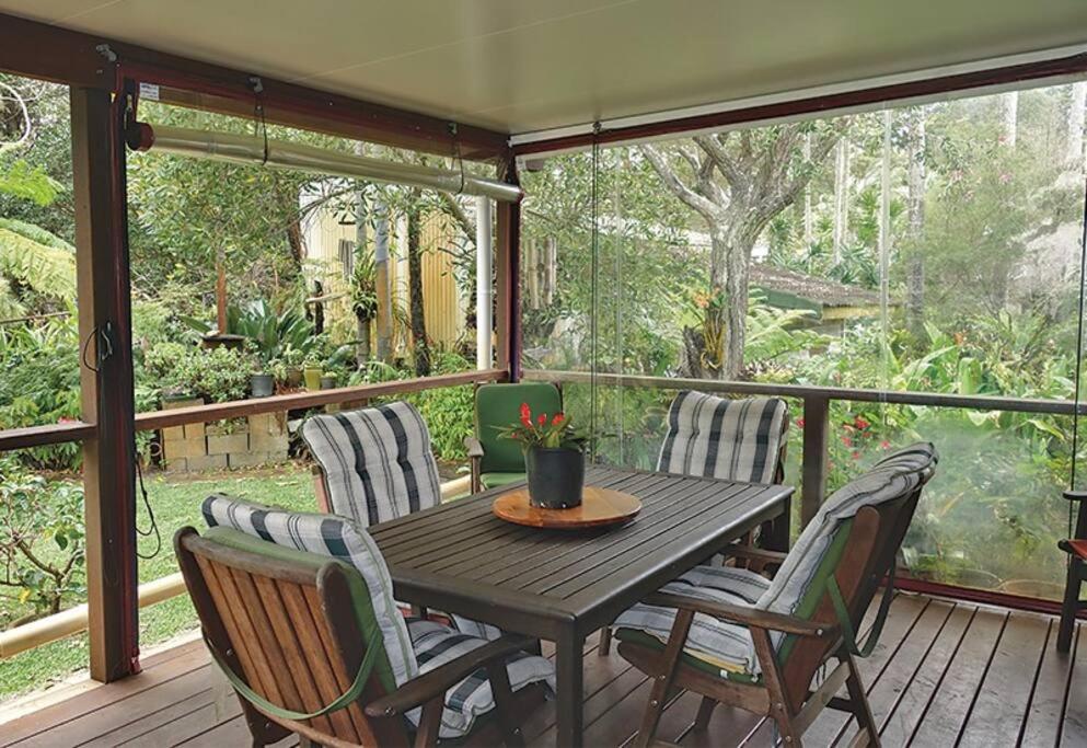 een veranda met een houten tafel en stoelen bij Anchorage in Amity Point