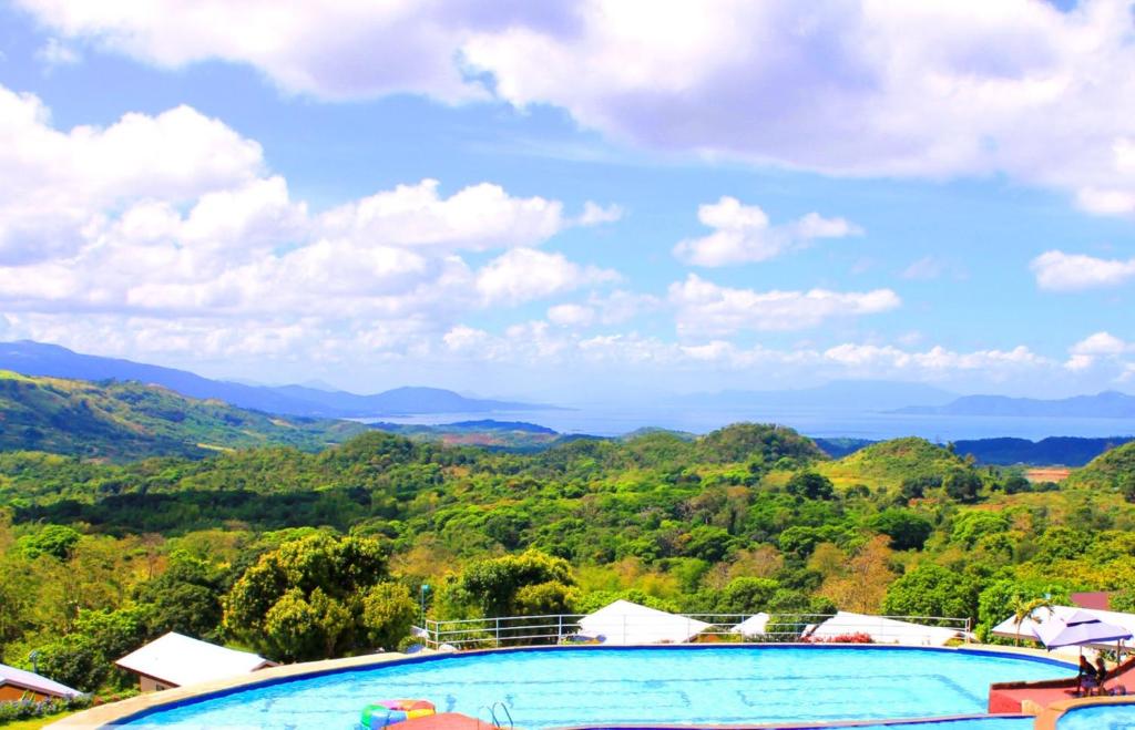 a swimming pool with mountains in the background at Bakasyunan Resort and Conference Center - Tanay in Tanay