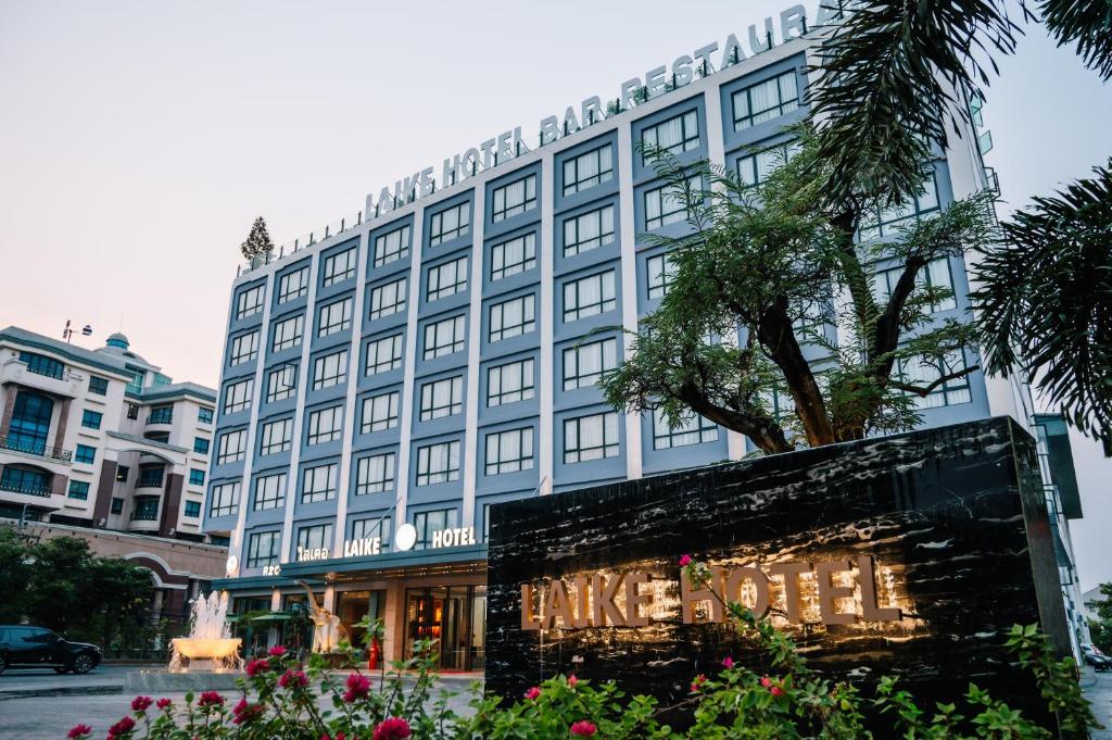 a large building with a sign in front of it at Laike Hotel in Bangkok