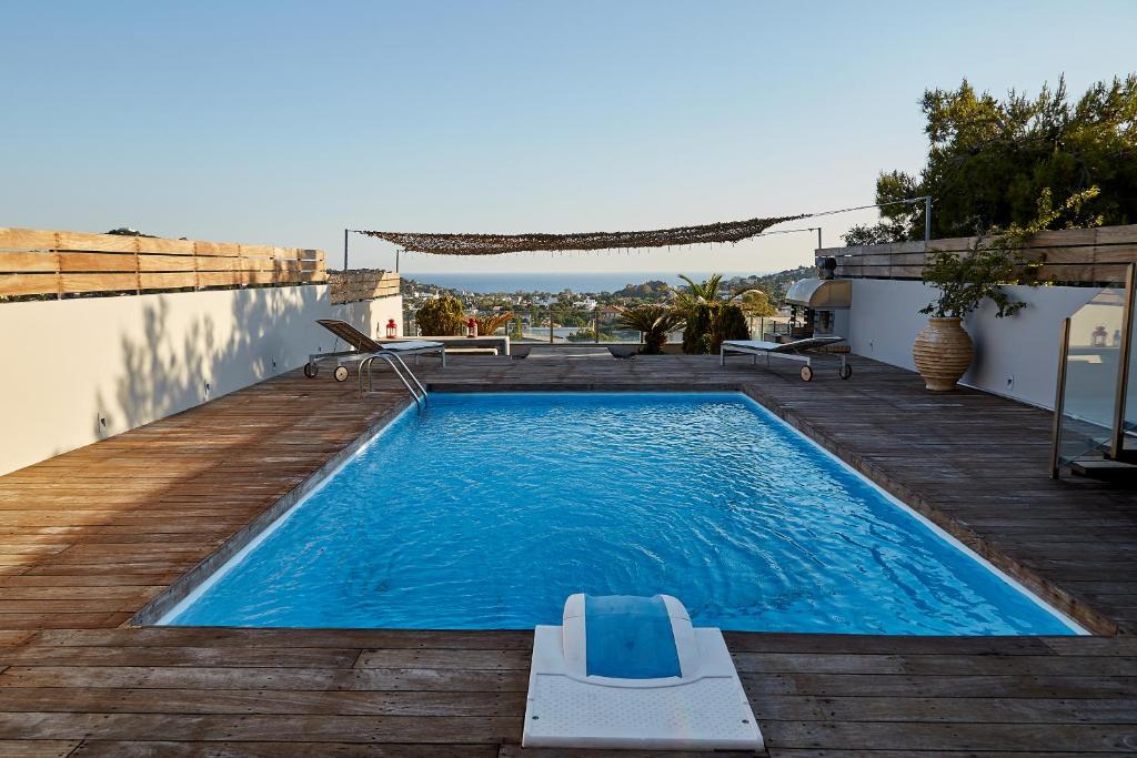 a swimming pool on a deck next to a house at Magnificent, Deluxe Villa, Lagonisi, Athens Riviera in Áyios Nikólaos