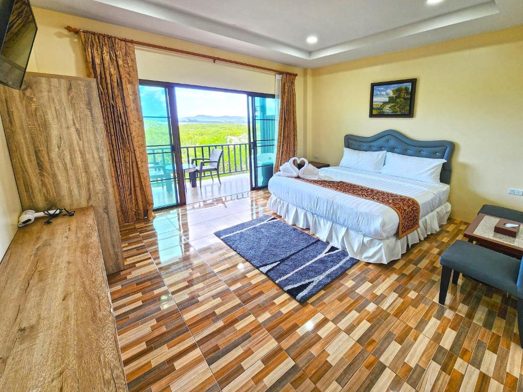 a bedroom with a bed and a balcony at So View Phuket Resort in Ban Sam Kong