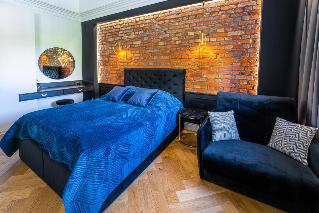 Un dormitorio con una cama azul y una pared de ladrillo en Oliwa Am Calsberg 5a en Gdansk