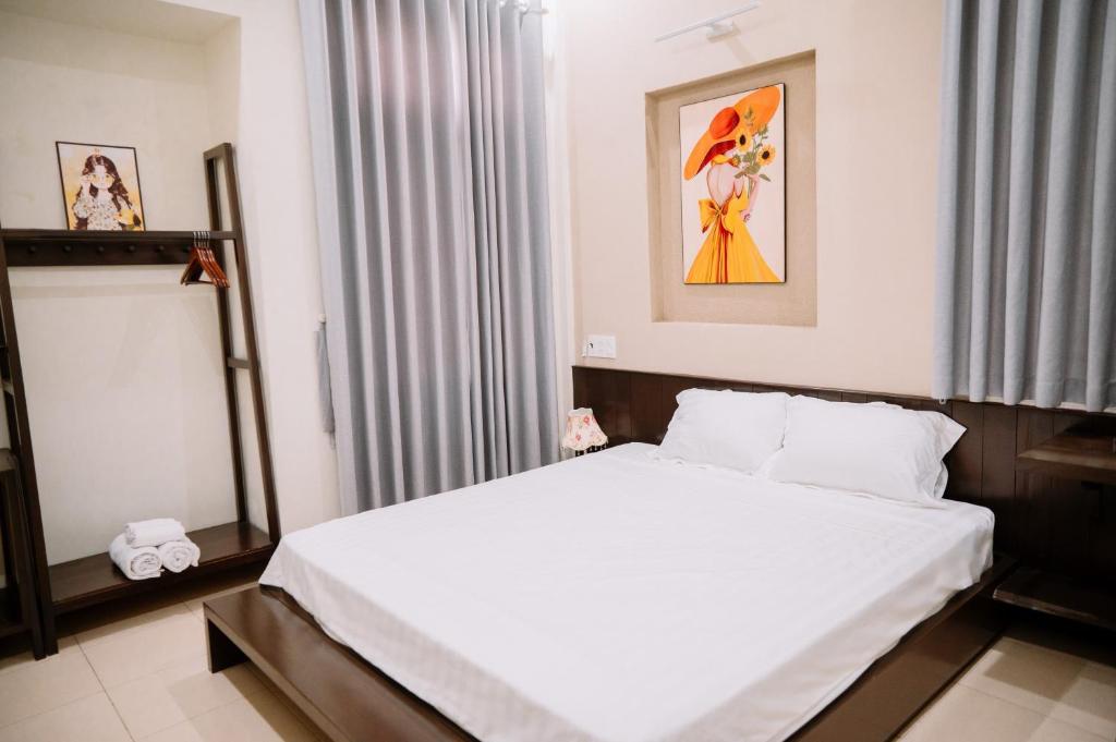 ein Schlafzimmer mit einem weißen Bett und einem Fenster in der Unterkunft ChiChi House in Hue