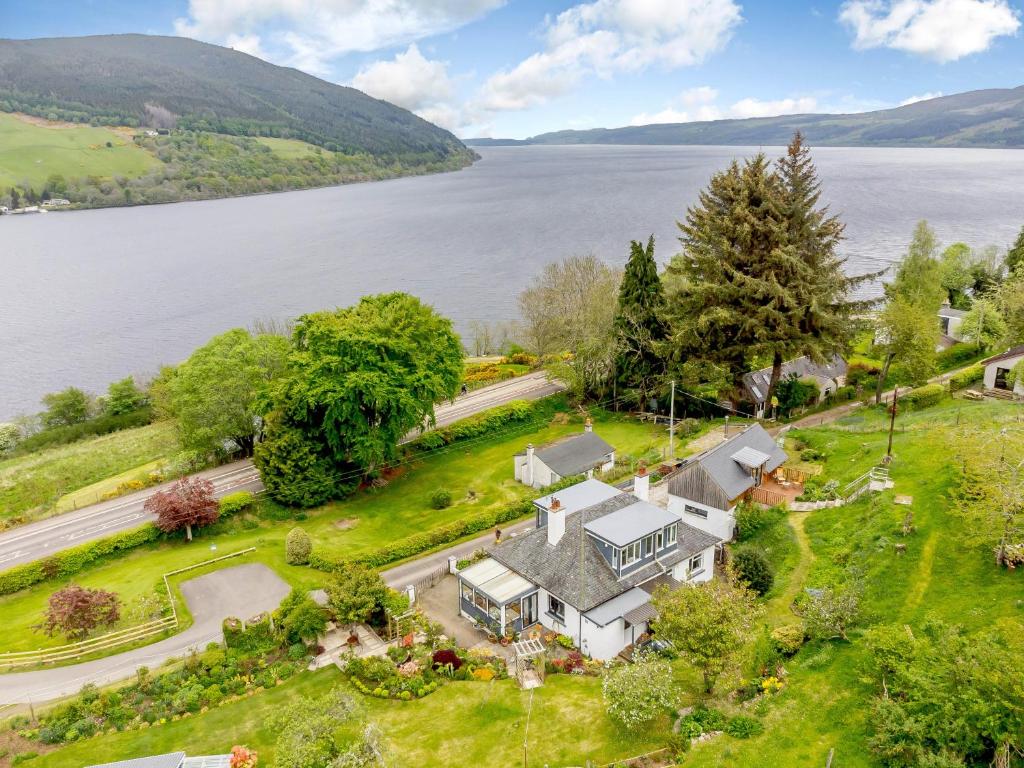 an aerial view of a large house with a lake at Urquhart Bay Croft in Drumnadrochit