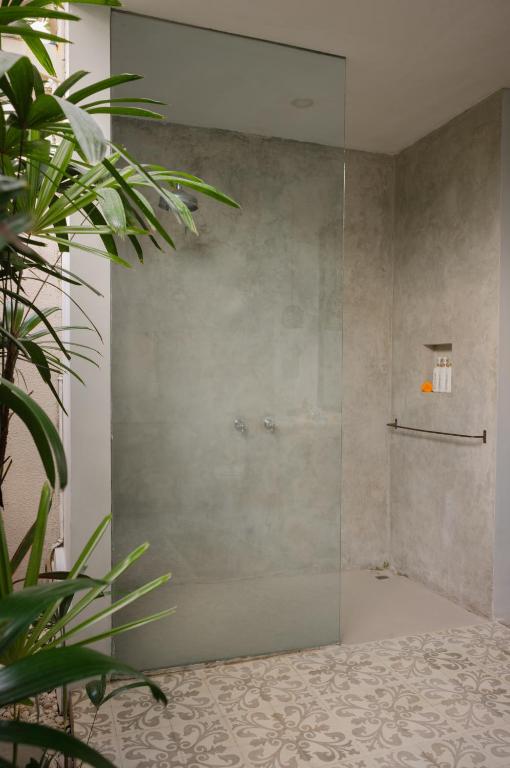 a shower with a glass door in a bathroom at The Bed by The Sea in Canggu