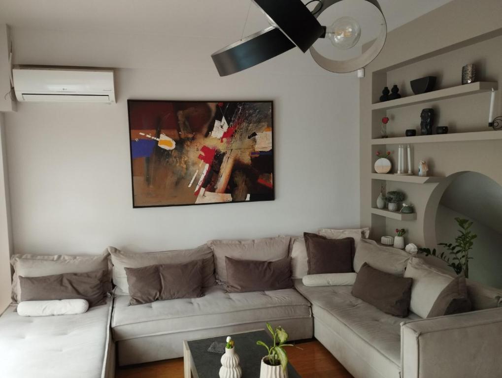 a living room with a couch and a painting on the wall at Villa Palmyra Athens in Athens