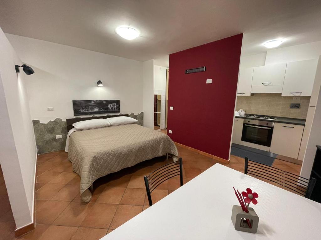 1 dormitorio con 1 cama con puerta roja y cocina en monolocale piano terra vicino aeroporto en Porto