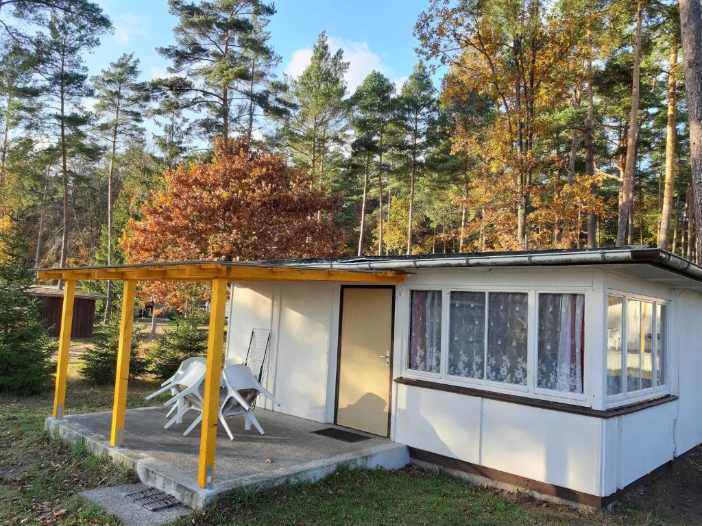 a tiny house with a porch and a chair at Ferienpark Seenland Betriebsgesellschaft mbH in Lychen