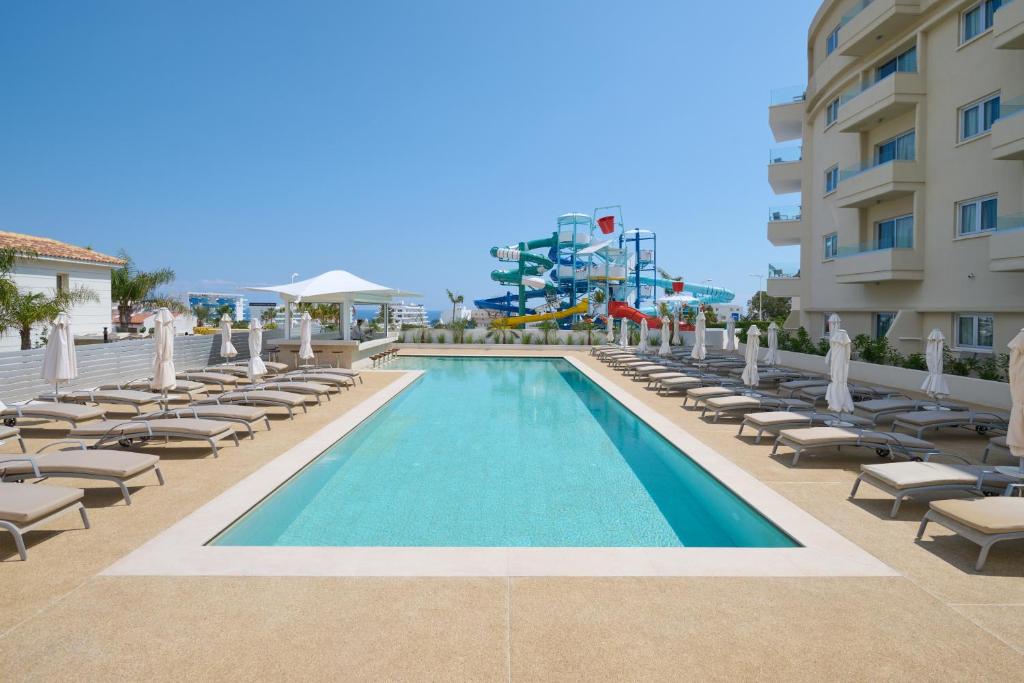 普羅塔拉斯的住宿－Sunrise Oasis Hotel & Waterpark，一个带躺椅的游泳池和一间酒店