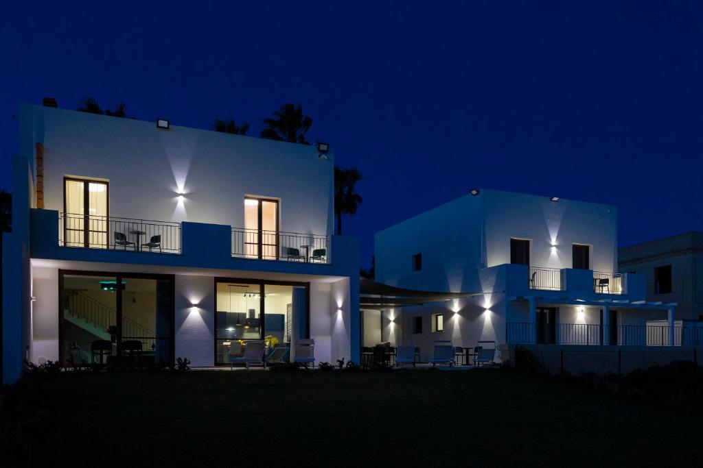 een groot wit huis 's nachts met verlichting bij Casa B, Room 4 - Palm Kite Paradise in Marsala