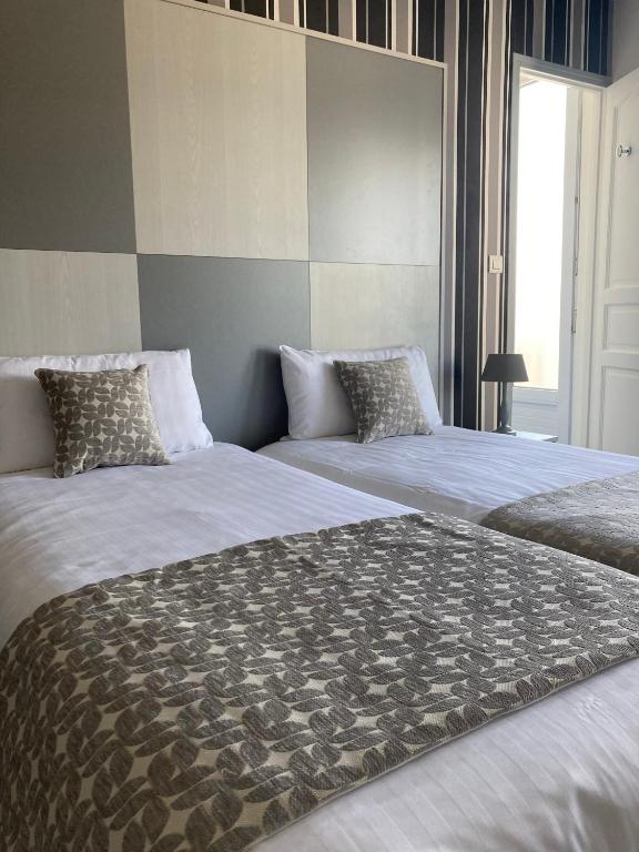 two beds sitting next to each other in a bedroom at Hotel Mona Lisa in La Baule
