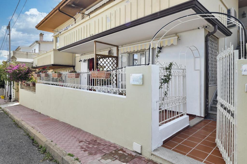 Edificio blanco con balcón y valla en Villa Isabel, en Cala Gonone