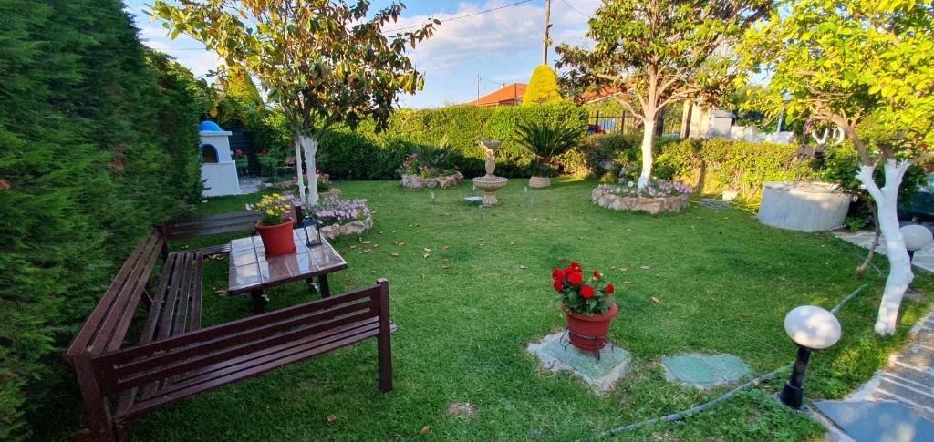 a garden with a bench and flowers in a yard at TSAGGA HOUSE in Oropos