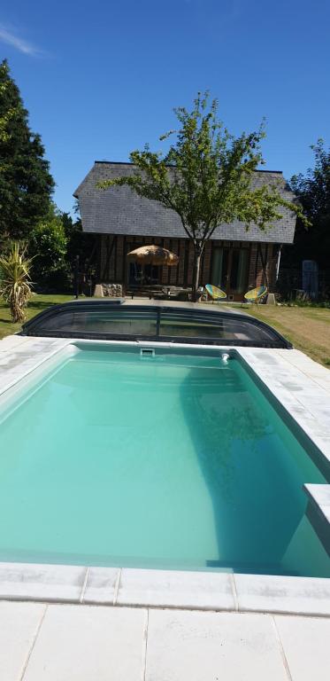 a swimming pool in front of a house at LES HIRONDELLES in Ingouville