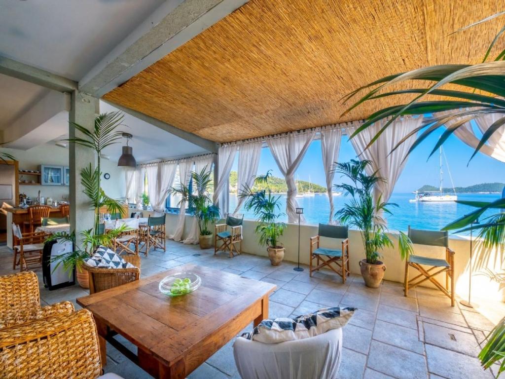 ein Wohnzimmer mit einem Tisch, Stühlen und Meerblick in der Unterkunft Villa Lola in Lopud Island