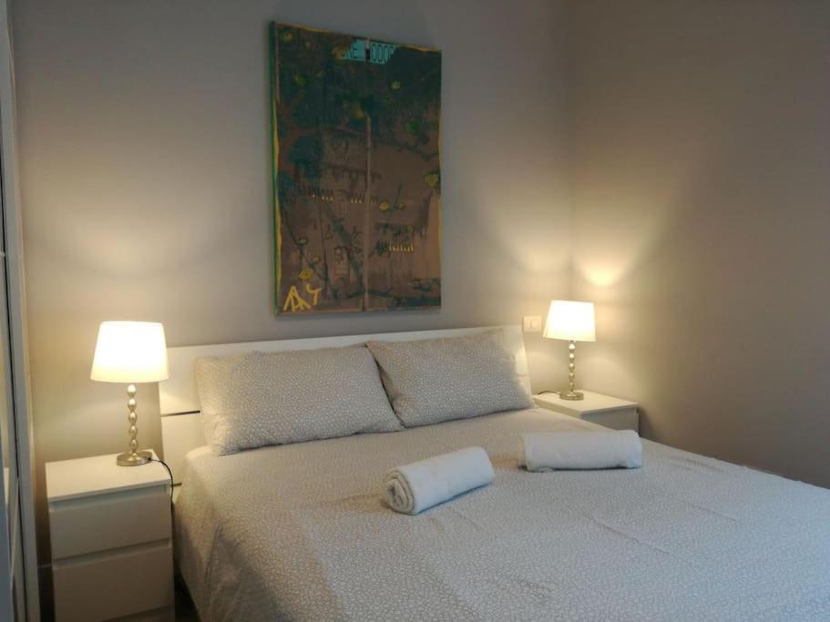 een slaapkamer met een wit bed en 2 lampen bij Suite MM3/Repubblica, 2 min. da Staz. Centrale (C2) in Milaan