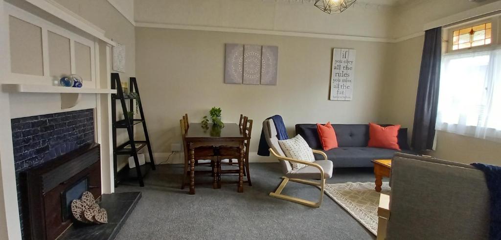sala de estar con sofá y chimenea en Character 2-Bedroom Unit en Masterton