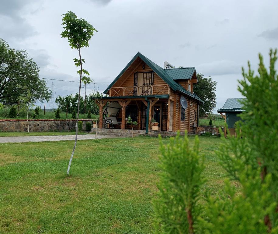 una casa di tronchi con un albero nel cortile di Guest House 