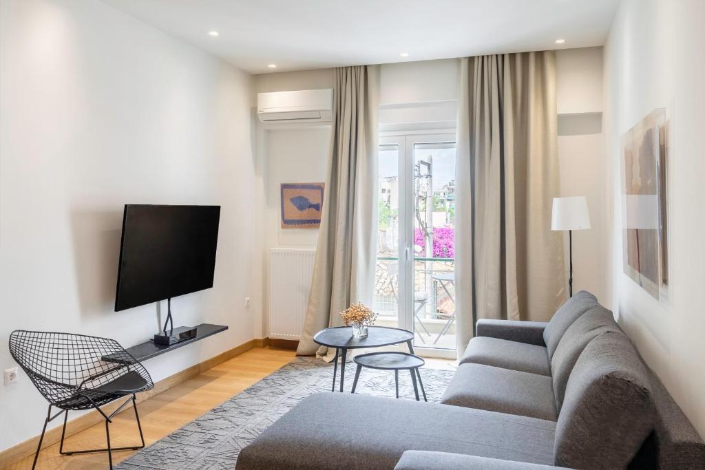 a living room with a couch and a tv at Luxury 1BR Flat in the Heart of Athens in Athens