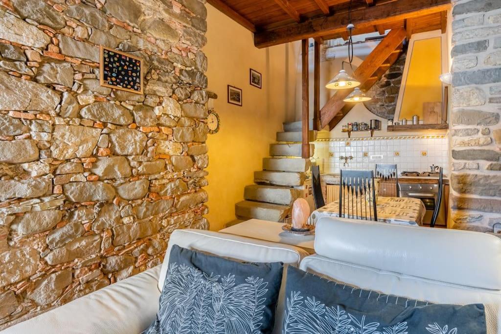 a living room with a stone wall and a couch at Villa Camelia Bianca in Barga