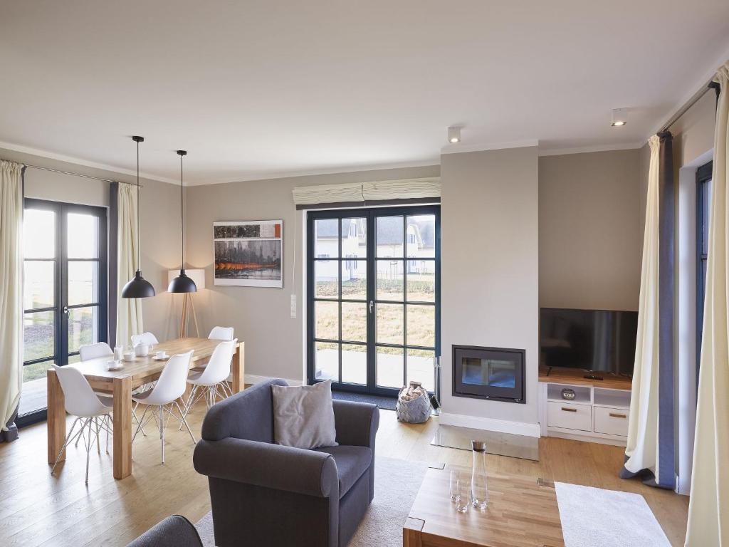 un salon avec un canapé et une table dans l'établissement Reetland am Meer - Premium Reetdachvilla mit 3 Schlafzimmern, Sauna und Kamin F09, à Dranske