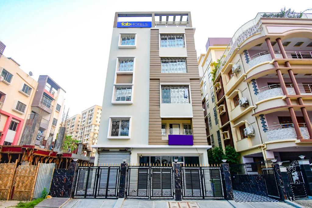 a tall building with a fence in front of it at FabHotel Trishiv - Newtown Kolkata in Kolkata