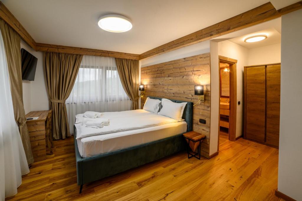 ein Schlafzimmer mit einem großen Bett in einem Zimmer in der Unterkunft Chalet First Hill in Gura Humorului