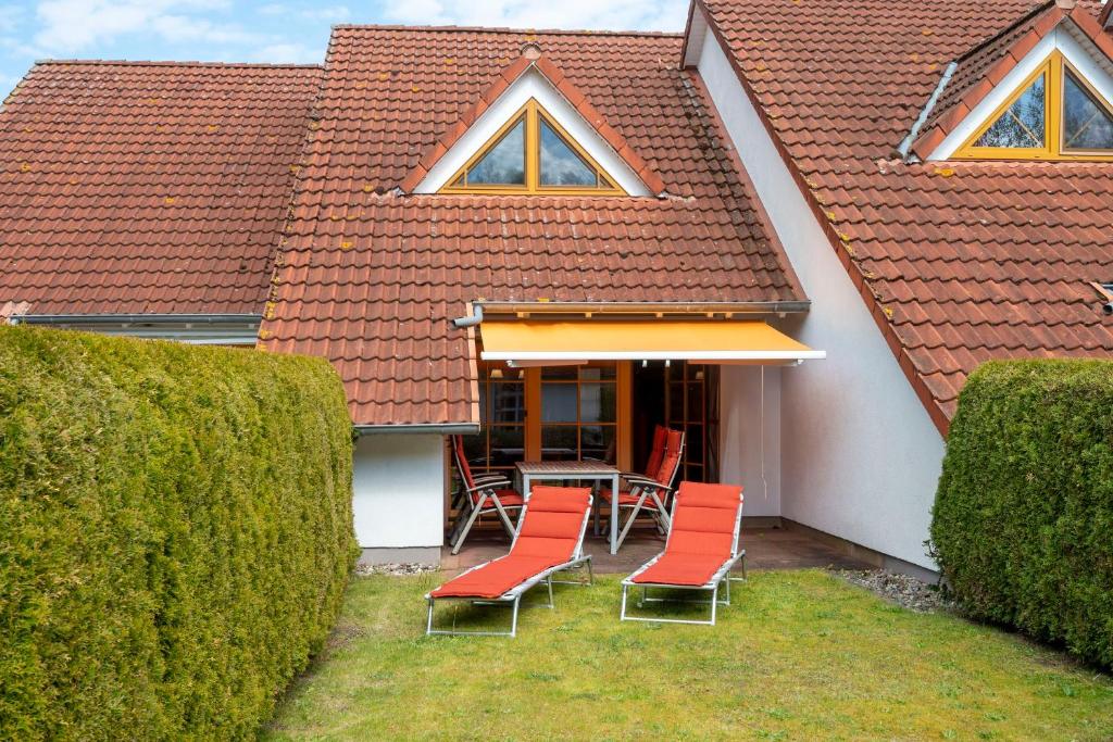 een patio met stoelen en een tafel in een huis bij Ferienpark Freesenbruch Reihenhaus 8b - Bivalvia in Zingst