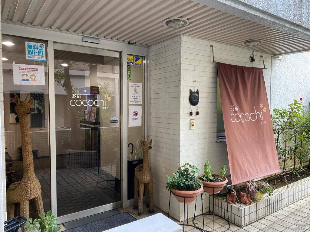 einen Laden mit Topfpflanzen und einem Fenster in der Unterkunft Oyado Cocochi in Tokio
