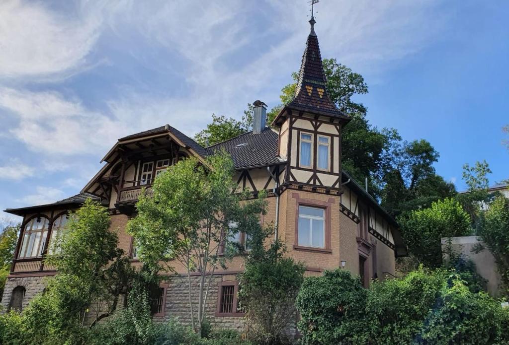 ein altes Haus mit einem Turm darüber in der Unterkunft Villa in Adelsheim in Adelsheim