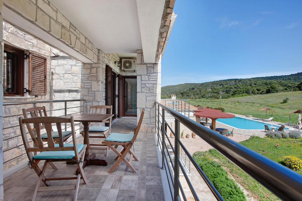 a balcony with a table and chairs and a pool at Wild Fig Retreat Sirocco in Maryiés