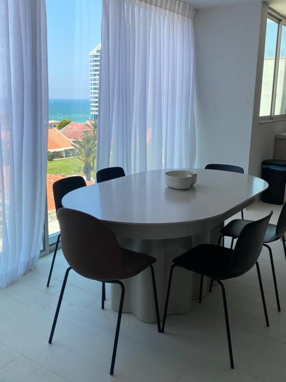 a white table and chairs in a room with a window at best sea view boutique two bedrooms in Herzliya