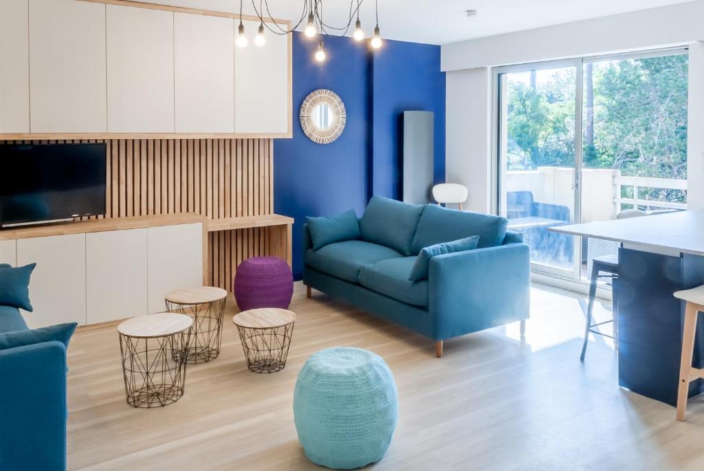 a living room with a blue couch and a table at 8 min de la plage, 2 de la gare, 15 de St-Nazaire in La Baule