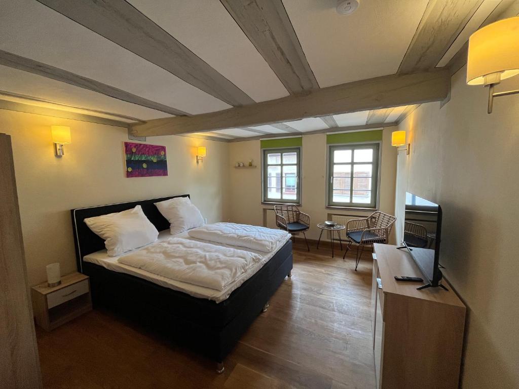 a bedroom with a bed and a tv in it at Gasthaus Zum Goldenen Hirsch in Schriesheim