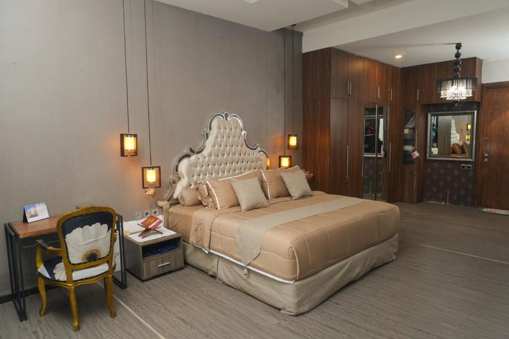 een slaapkamer met een groot bed en een stoel bij Casa de Saka Villa in Ngaglik
